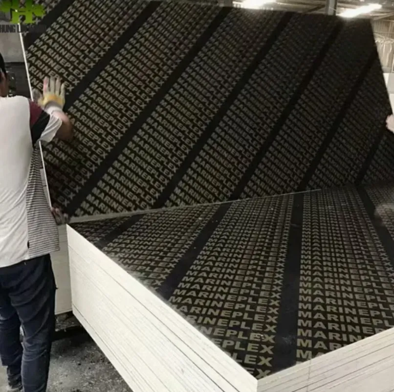Worker handling Marineplex film-faced plywood sheets at factory